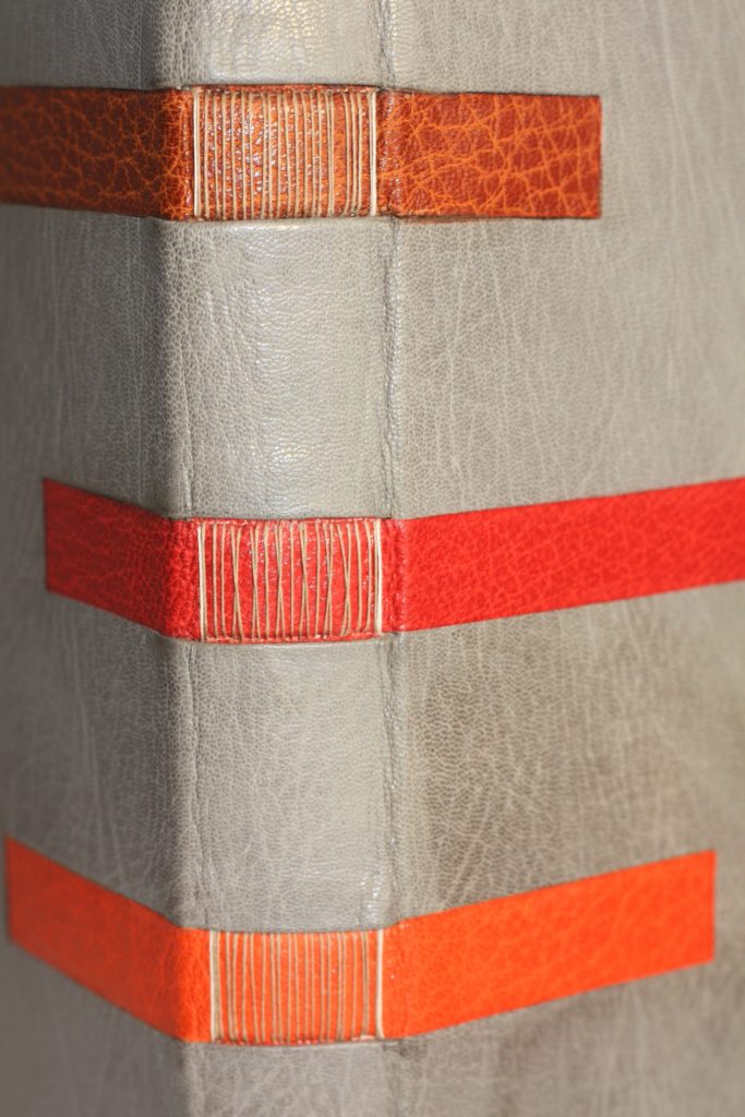Couture apparente sur bande de cuir